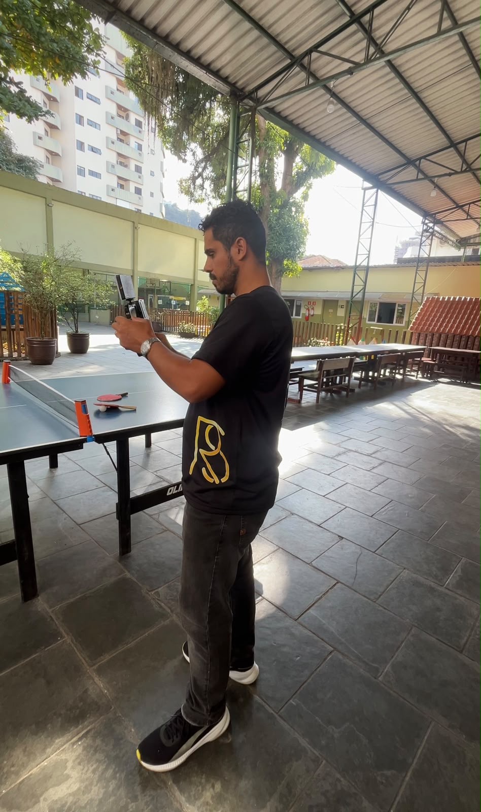 Tiago gravando conteúdo na área externa de uma escola